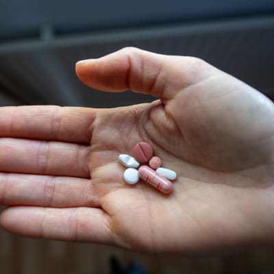 En person håller i antidepressiva läkemedel i sin hand. Totalt sex piller.