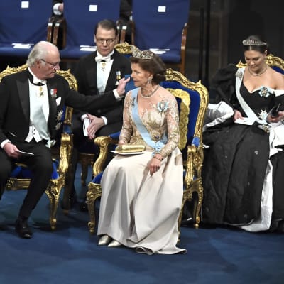 Svenska kungafamiljen sitter i gyllene stolar på Nobelgalan 2019. 