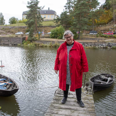 Marikki Hakola står på en brygga i Borgå å. Bakom henne guppar en Göteborgs eka och en jolla.