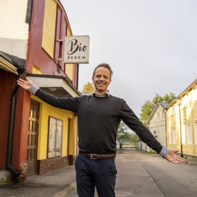 En man står utanför Bio Forum i Ekenäs och håller välkomnande ut händerna