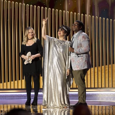 Amy Poehler, Maya Rudolph ja Kenan Thompson seisovat lavalla.