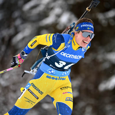 Elvira Öberg hiihtää metsässä.