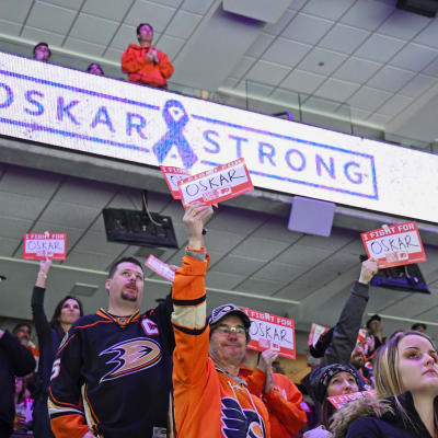 Fans håller upp pappersark för att hylla Oskar Lindblom.