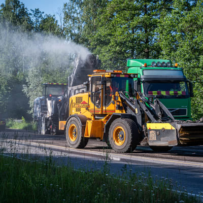 Män och maskiner jobbar med att asfaltera