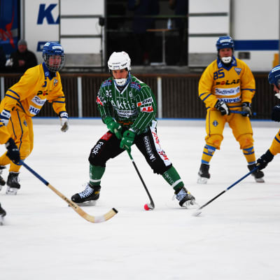 Denis Sadakov, iklädd Akilles-grönt, håller i bollen och är omringad av gulklädda OLS-spelare.