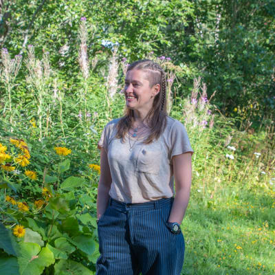 Penny Nymark står i en trädgård.
