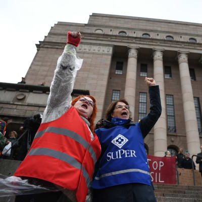 Millariikka Rytkönen och Silja Paavola demonstrerar utanför riksdagshuset.