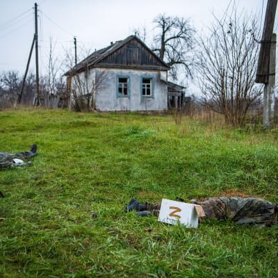 Döda ryska soldater ligger på en gräsmatta i byn Makiivka efter strider där.