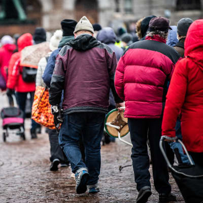 Personer i brödkö vid Helsingfors järnvägsstation.