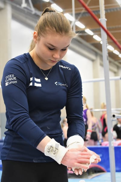 Gymnasten Maisa Kuusikko sätter magnesium på händerna.