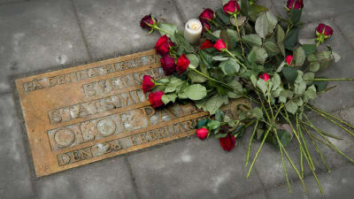 Blommor vid en minnesplakett över Olof Palme