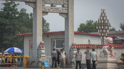 Poliser och säkerhetstjänst bevakade porten till begravningsplatsen i Shenyang på fredagen 14.7.2017.