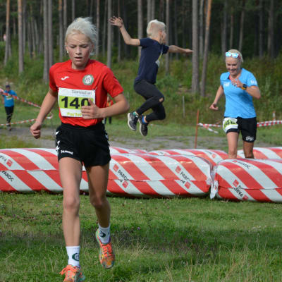 Michaela Lindström springer i mål bakom dottern Amanda i Saaristo trail. Också sonen Viktor med.