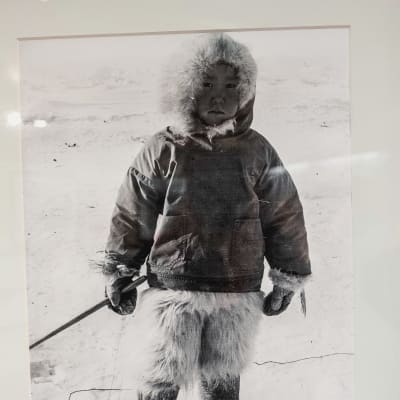 Mustavalkoinen valokuva, pieni lapsi pukeutuneena turkiksiin