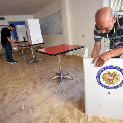 Vaalivirkailija kasaa äänestyskoppia.