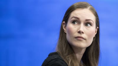 Sanna Marin tittar åt sidan. 