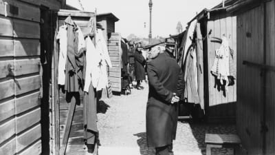 Man på Narinkens köpplats, mellan låga hus. 1920-tal