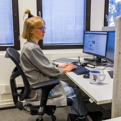 Toimittaja Sara Salmi istuu työpöydän ääressä ja kirjoittaa tietokoneella.