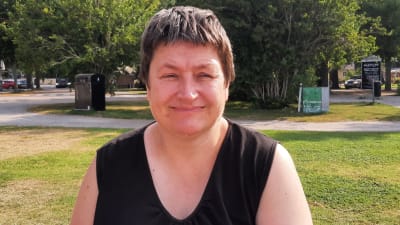 Kvinna med svart skjort i park.
