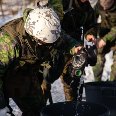 Sotilas pesee kaasunaamaria harjoituksen jälkeen.