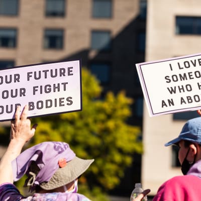 Kaksi mielenosoittajaa ajamassa aborttioikeutta kylttien kanssa.