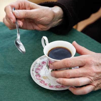 Händer och en kaffekopp.