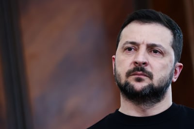 På en närbild är Ukrainas president Volodymyr Zelenskyj iklädd mört t-tröja och ser bestämd ut.