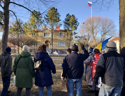 Tio personer i demonstration med Ukrainas flagga utanför ryska konsulatet i Mariehamn