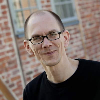 Hugo Strandberg framför en tegelvägg.