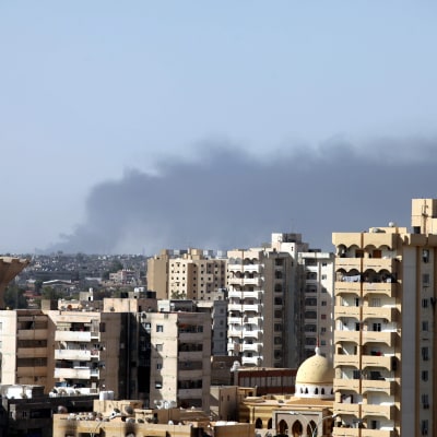 Rök stiger från strider kring flygplatsen i Tripoli.