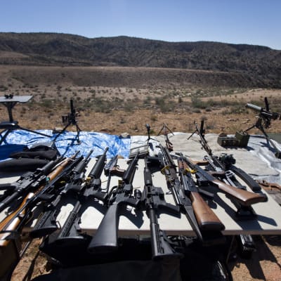 En rad automatvapen på ett bord inför en skytteträff i Arizona, USA