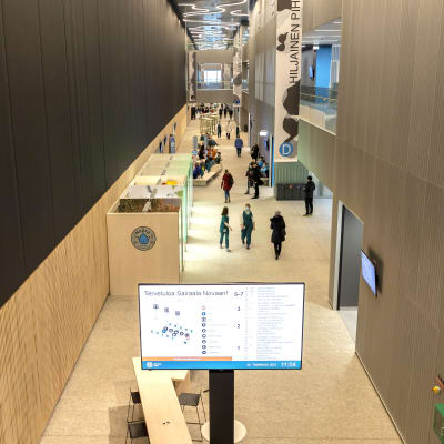 Människor går i aulan i Mellersta Finlands centralsjukhus.
