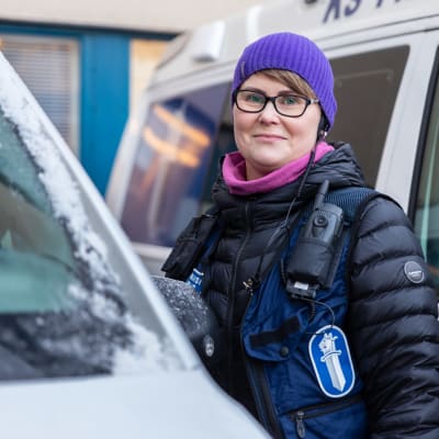 Maarit Hänninen poliisiauton vieressä.