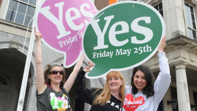 Tre kvinnor håller upp plakat för att fira att ja-sidan segrade i den irländska folkomröstningen om abortlagar i maj 2018. 