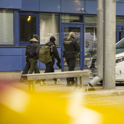 Rajavartija saattaa kolme turvapaikanhakijaa rajanylityspaikalla.