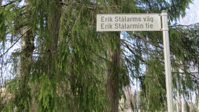 En gatuskylt, Erik Stålarms väg. Bakom en stor gran