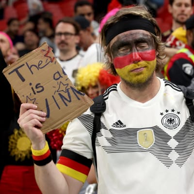 Saksalainen jalkapallokannattaja on repinyt pahvikyltin kahtia, jossa lukee: "Unelma on elossa"
