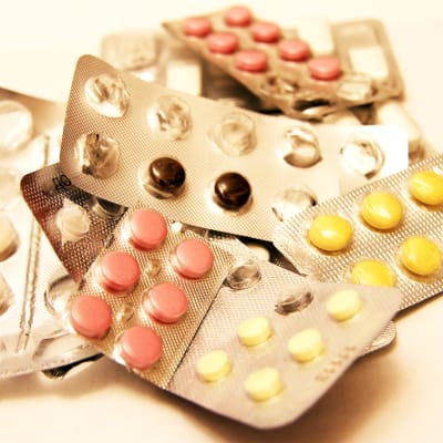 Pillerkartor i en hög innehållandes olika typer av mediciner.