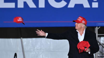 Ex-presidenten Donald Trump kastar hattar till publiken under ett kampanjjippo i Arizona.
