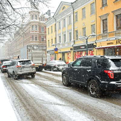 Bilar i snöfall på Norra Esplanaden i Helsingfors.
