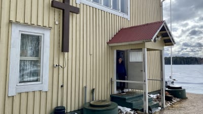 En kvinna står vid ett bönehus.