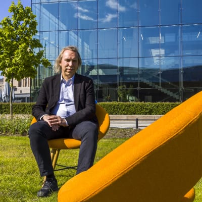 Teppo Kröger, yhteiskuntapolitiikan professori, istuu oranssilla tuolilla.