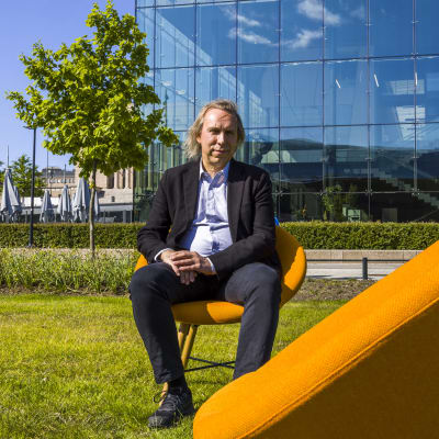 Teppo Kröger, yhteiskuntapolitiikan professori, istuu oranssilla tuolilla.