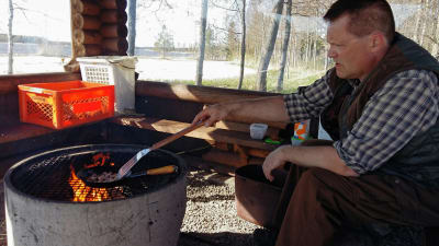 Stefan Pellas steker en kolbulle över öppen eld.
