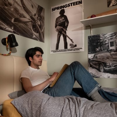 Javed (Viveik Kalra) sitter på sin säng och lyssnar på Bruce Springsteen.