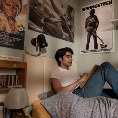 Javed (Viveik Kalra) sitter på sin säng och lyssnar på Bruce Springsteen.