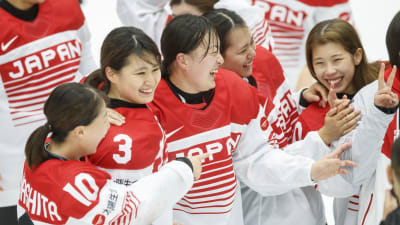 Japanska spelare firar seger över Finland.