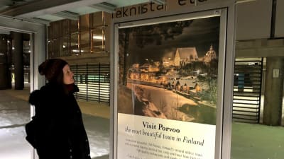 Kvinna som ute ser på en reseaffisch.