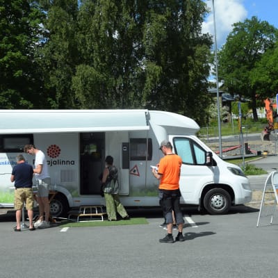 Människor utanför fästingbuss.