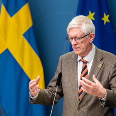 Johan Carlson, generaldirektör på Folkhälsomyndigheten, på pressträff på regeringskansliet framför svenska flaggor.